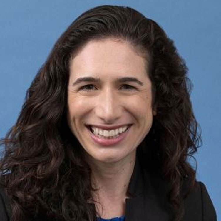 Portrait image of Jennifer Sumner smiling with blue background